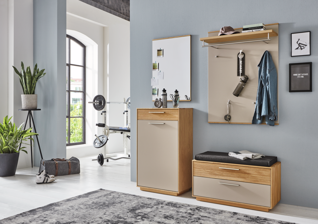 Moderne Garderobeneinrichtung mit Schuhschrank, Sitzbank und Garderobenpaneel in einem hellen Raum mit Blick auf ein Fenster.