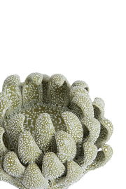 Nahaufnahme eines dekorativen Teelichthalters in Grün mit weißen Punkten, die an eine blühende Blume erinnern.