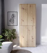 Hochformatiger XL-Schuhschrank aus hellem Holz mit vier Türen, frontal fotografiert. Der Schrank steht in einem modernen Raum neben einem Sofa und einer Pflanze.