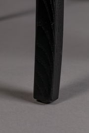 Nahaufnahme eines schwarzen Stuhlbeins auf grauem Hintergrund, von der Seite betrachtet.