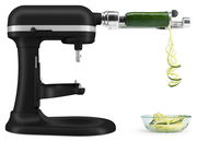 Schwarze Küchenmaschine Heavy Duty 5,2L mit Spiralaufsatz, der Zucchini in Spiralen schneidet, seitliche Perspektive.