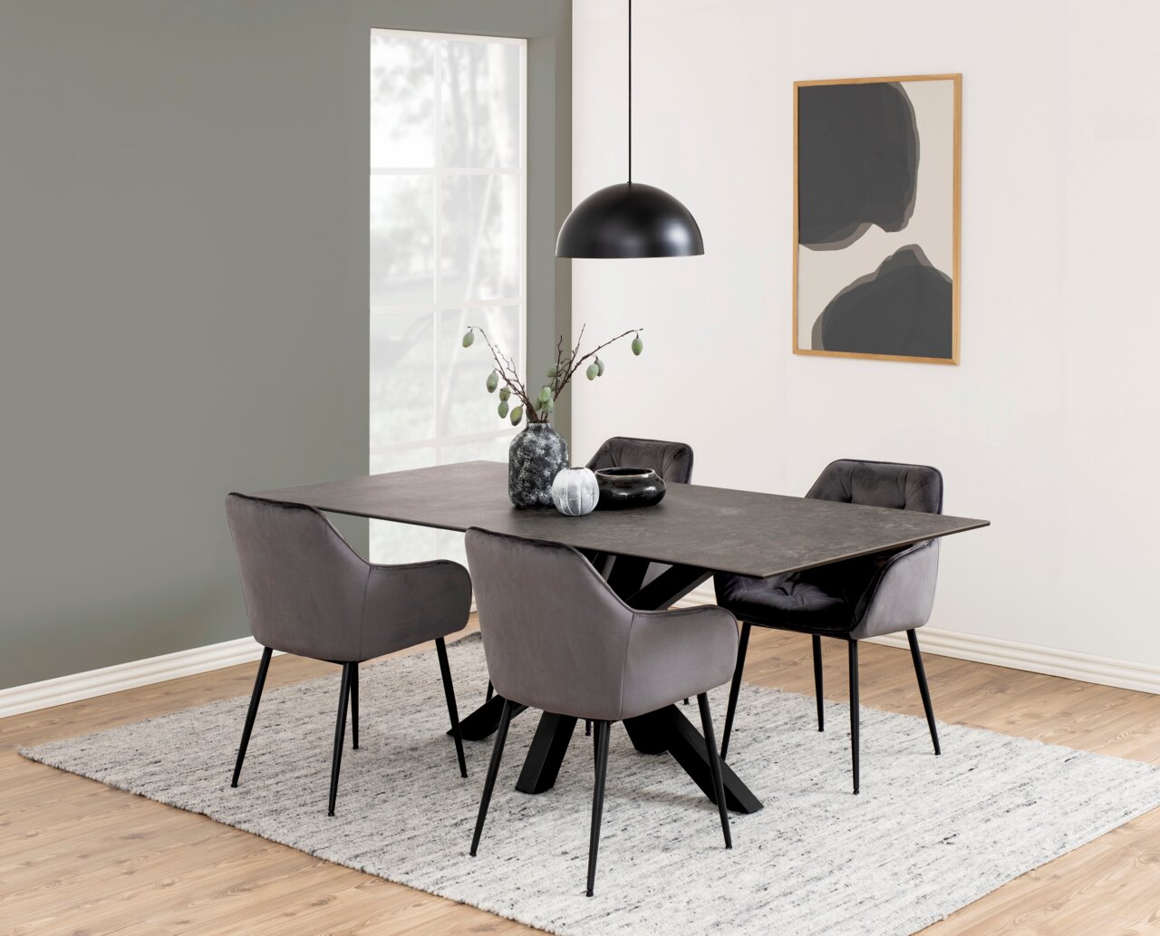 Moderne eettafel met een donker tafelblad en vier grijze stoelen, gezien vanaf de zijkant.