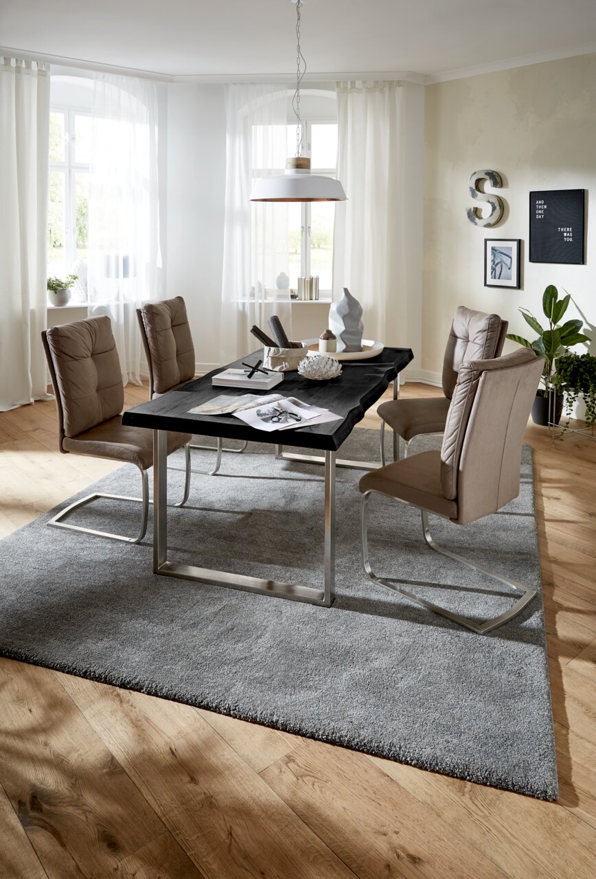 Moderne Esszimmeransicht mit einer Tischplatte 160x90 cm in dunklem Holz, umgeben von beigen Stühlen auf einem grauen Teppich. Die Perspektive zeigt den Tisch von der Seite mit Blick auf das gesamte Esszimmer.