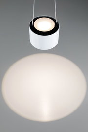Hängende zylindrische Pendelleuchte in Weiß mit direkter Draufsicht, die einen breiten Lichtkegel auf eine graue Oberfläche wirft.