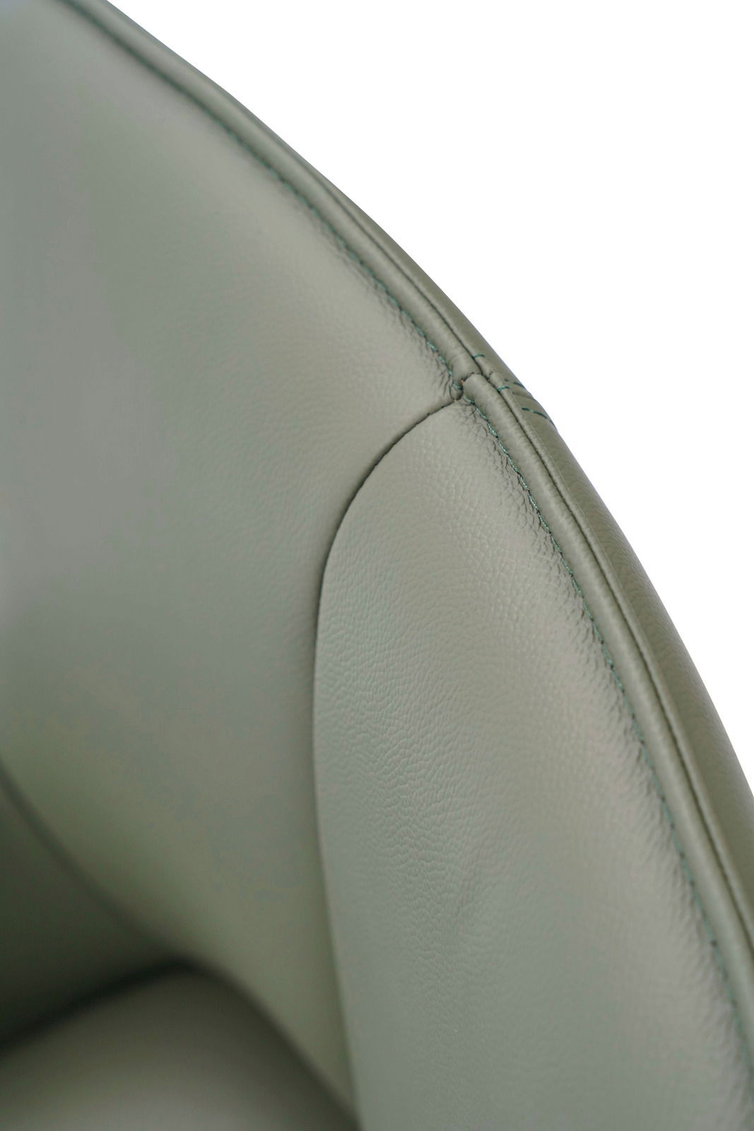 Nahaufnahme eines grünen Armlehnstuhls aus Leder, Fokus auf die Naht und Textur der Rückenlehne.