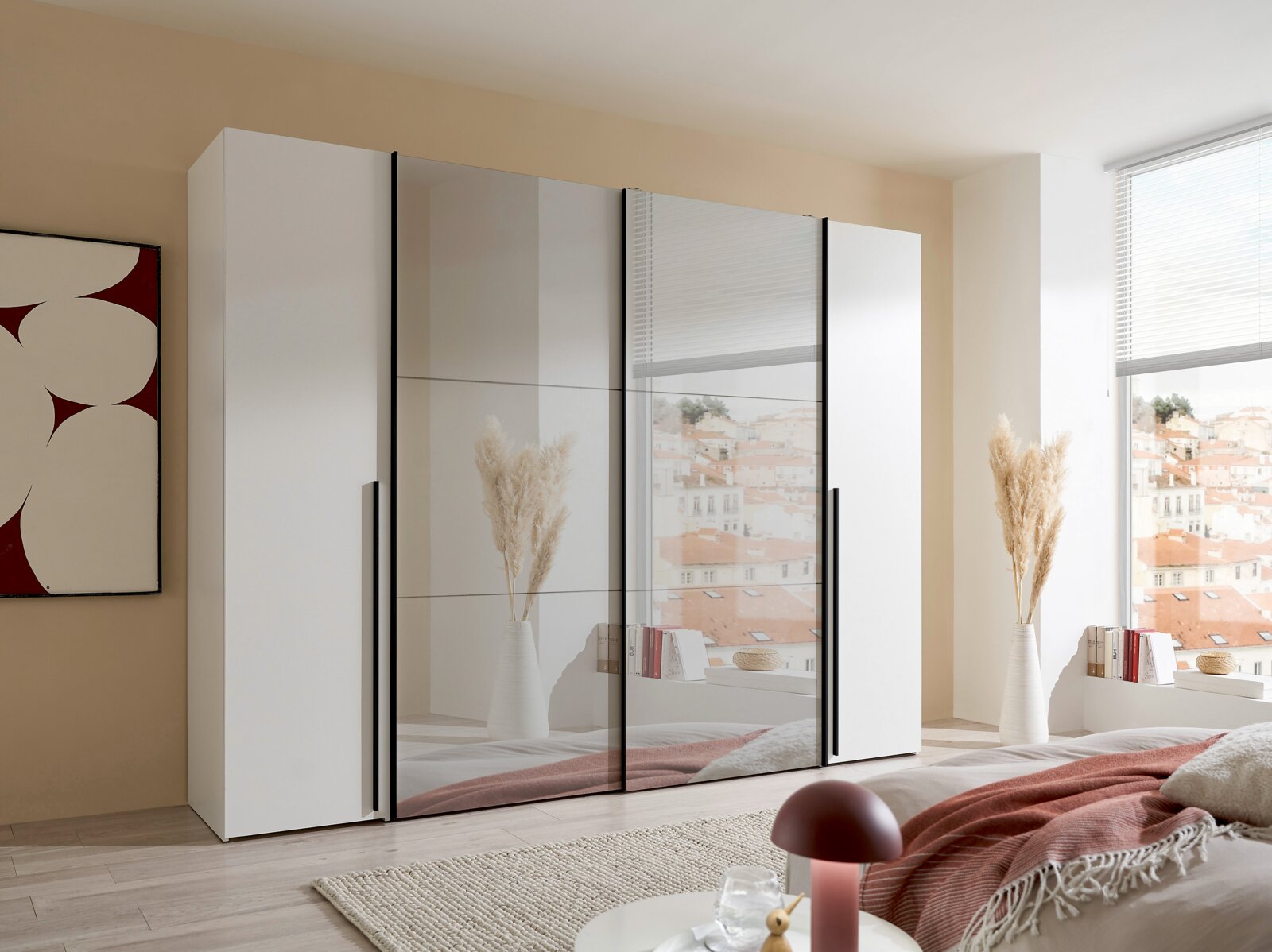 Moderner Dreh- und Schwebetürenschrank mit vier Türen, teils mit Spiegel, in einem stilvollen Schlafzimmer aus der Perspektive von vorne rechts.