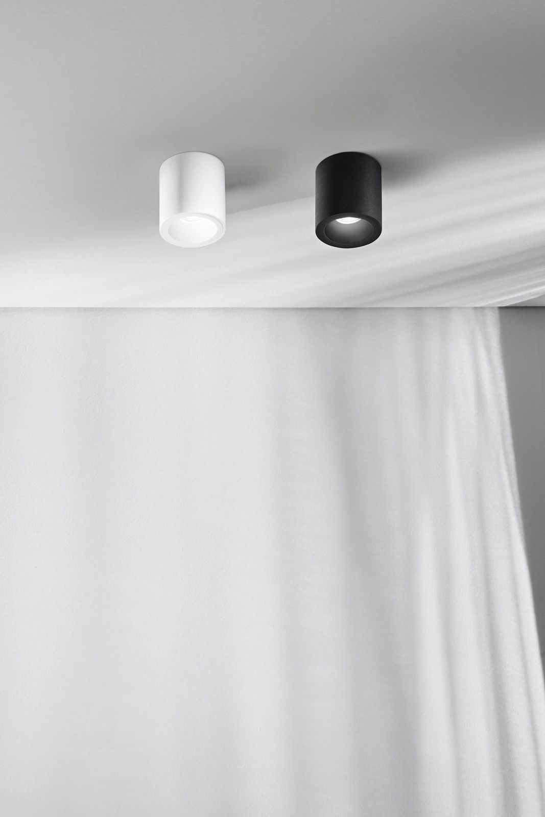 Fabas Luce Aufbauspot GUAMO Zwei zylindrische Aufbauspots in Schwarz und Weiß an der Decke, seitliche Perspektive