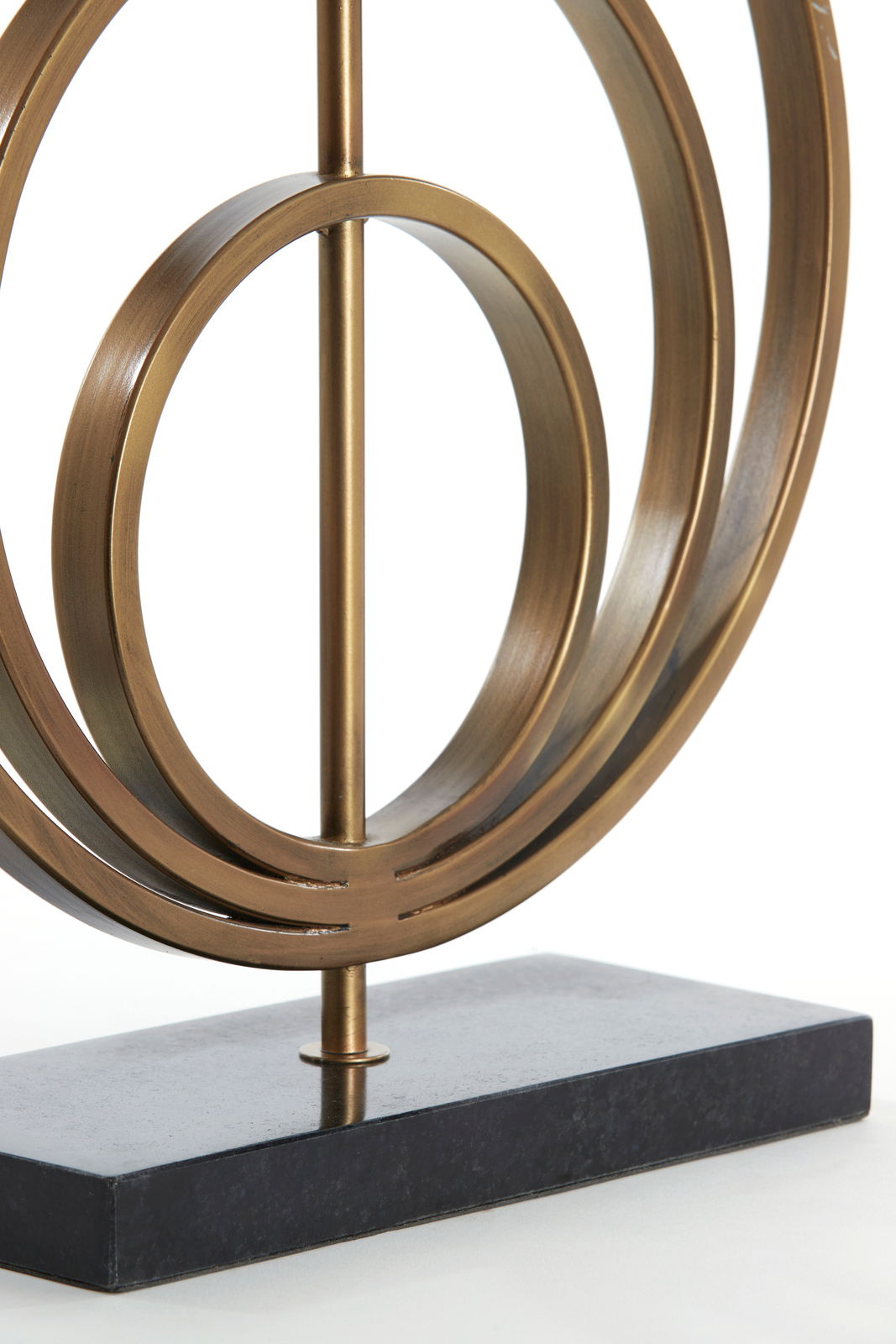 Nahaufnahme eines dekorativen Lampenfußes aus Metall mit kreisförmigem Design auf einem rechteckigen Sockel, seitliche Perspektive.