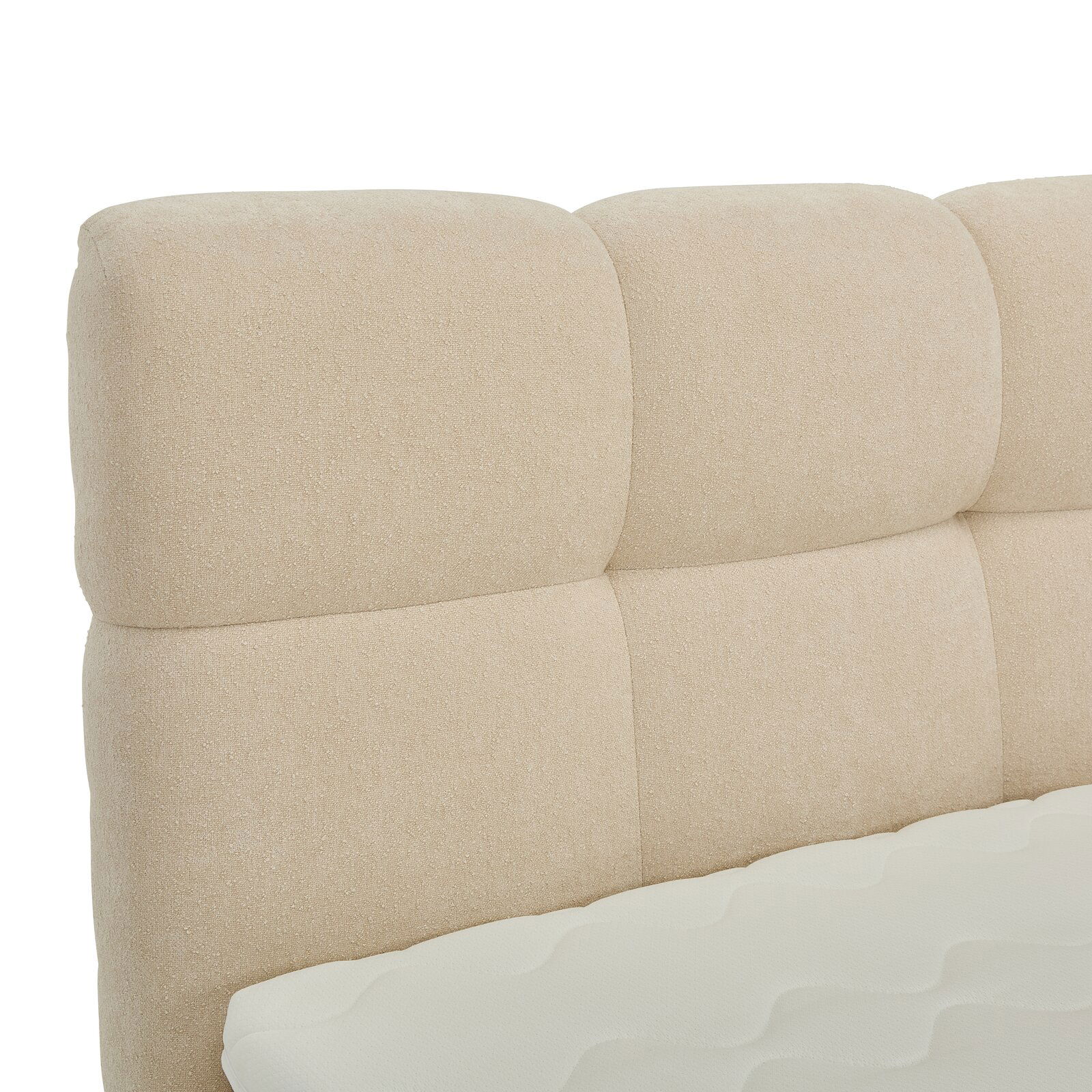 Nahaufnahme eines beigen Boxbett-Kopfteil mit gepolstertem Design, seitliche Perspektive
