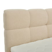 Nahaufnahme eines beigen Boxbett-Kopfteil mit gepolstertem Design, seitliche Perspektive