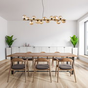 Moderne Hängeleuchte mit mehreren Glaskugeln, von der Seite betrachtet, über einem Esstisch in einem stilvollen Esszimmer.