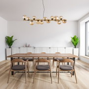 Moderne Hängeleuchte mit mehreren Glaskugeln, von der Seite betrachtet, über einem Esstisch in einem stilvollen Esszimmer.