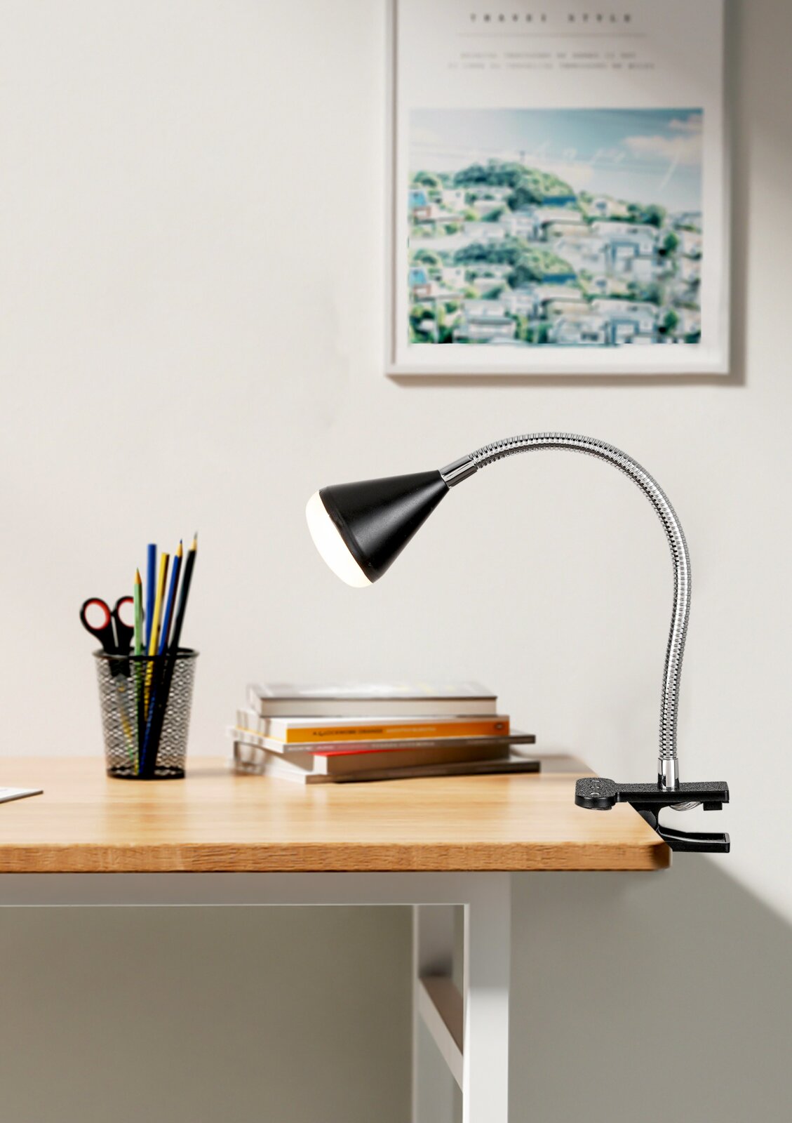 LED-Klemmleuchte in seitlicher Perspektive auf einem Schreibtisch, mit flexiblem Hals und schwarzem Lampenschirm.