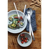 Vogelperspektive auf ein elegantes 4-teiliges Servier-Set aus Edelstahl, präsentiert mit gegrilltem Gemüse und Tomaten auf einem rustikalen Holztisch.