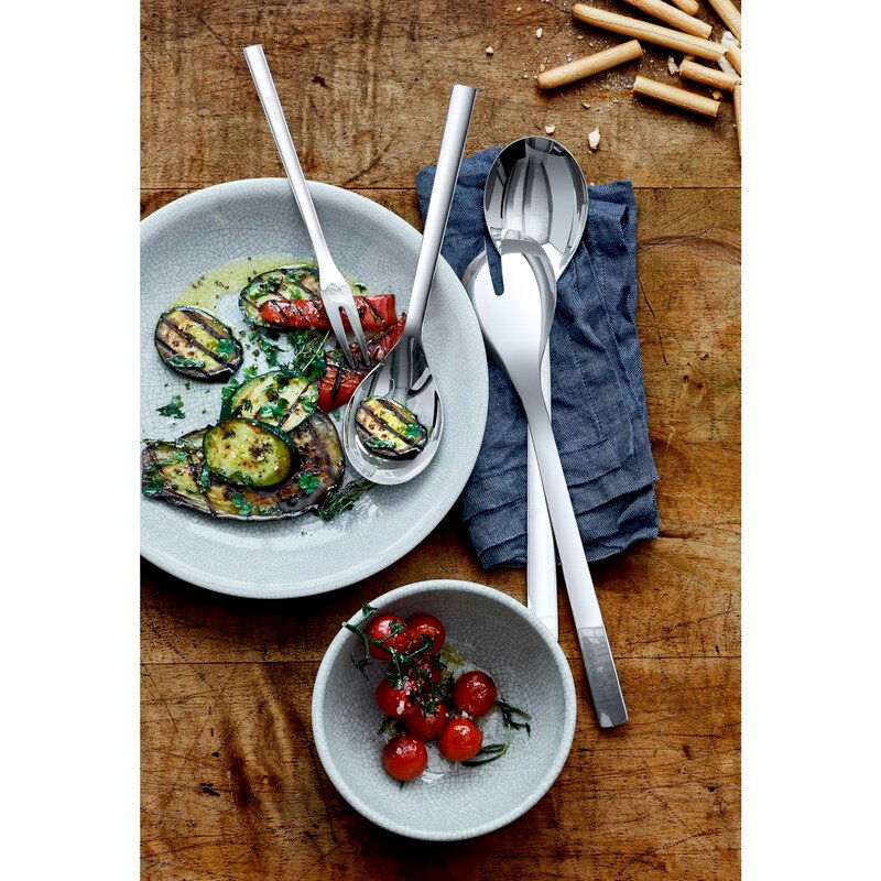 WMF Servierteile-Set 4-tlg. NUOVA Vogelperspektive auf ein elegantes 4-teiliges Servier-Set aus Edelstahl, präsentiert mit gegrilltem Gemüse und Tomaten auf einem rustikalen Holztisch.
