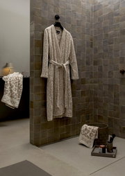 Beige badjas met luipaardprint van JOOP! in een moderne badkamer, recht voor de camera aan de muur opgehangen.