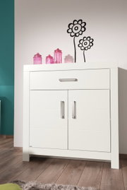 Weißes Highboard mit zwei Türen und einer Schublade, dekoriert mit rosa Gläsern, aus frontaler Perspektive fotografiert.