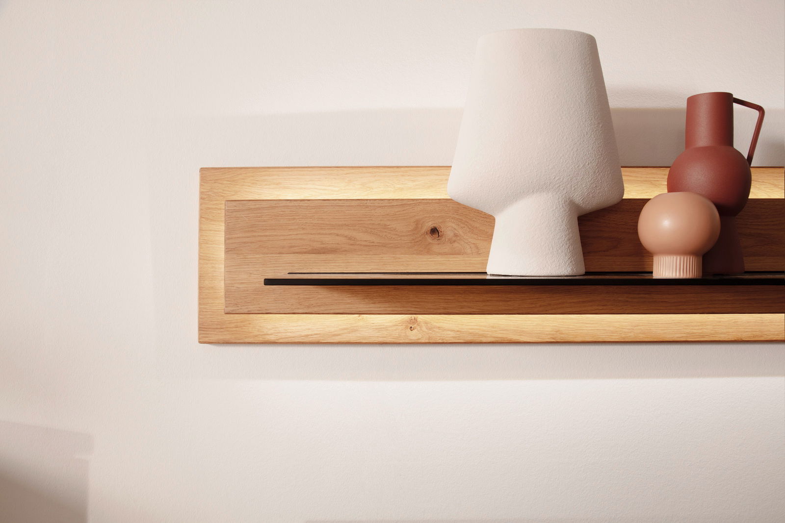 Frontale Ansicht eines modernen Wandboards aus Holz mit integrierter Beleuchtung, dekoriert mit stilvollen Vasen und einer Lampe.