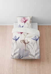 Bettwäsche-Set mit floralem Muster in sanften Farben, aus der Vogelperspektive fotografiert.