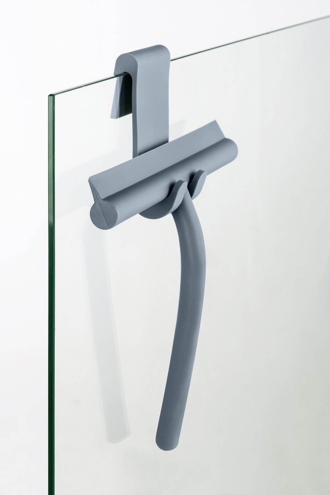 Schöner Wohnen Badezimmerwischer Grauer Badezimmerwischer aus Silikon, aufgehängt an einer Glasduschwand, seitliche Perspektive.