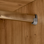 Nahaufnahme einer Kleiderstange in einem Kleiderschrank, montiert an einer Holzplatte.