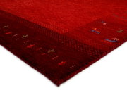 Roter Wollteppich mit dezenten Mustern, seitliche Perspektive
