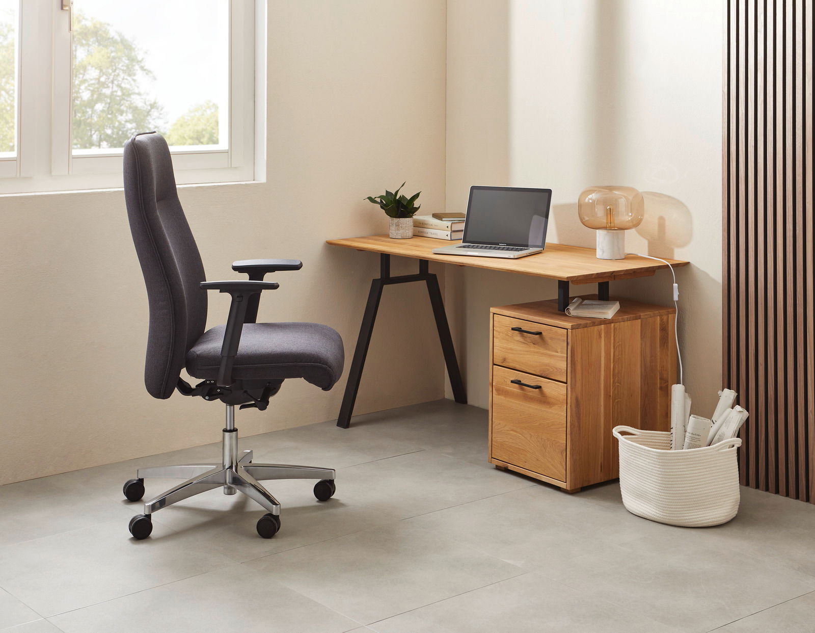 Topstar XL-Drehstuhl COMFORT CHIEF Bürostuhl in Seitenansicht neben einem Schreibtisch mit Laptop und Lampe, in einem modernen Büro.