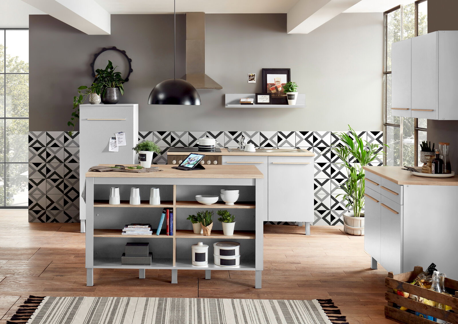 Moderne Kücheninsel mit Holzarbeitsplatte und offenen Regalen, umgeben von stilvollen Küchenschränken und Dekorationen, aus der Perspektive des Küchenraums.