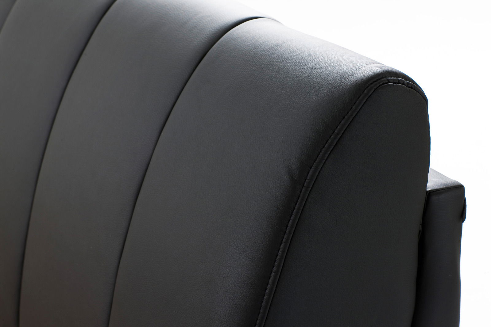 Nahaufnahme eines schwarzen, gepolsterten Bettrückenteils aus Leder, seitliche Perspektive