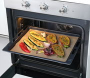 Dauerbackfolie in einem Ofen mit gebackenem Gemüse, seitliche Perspektive