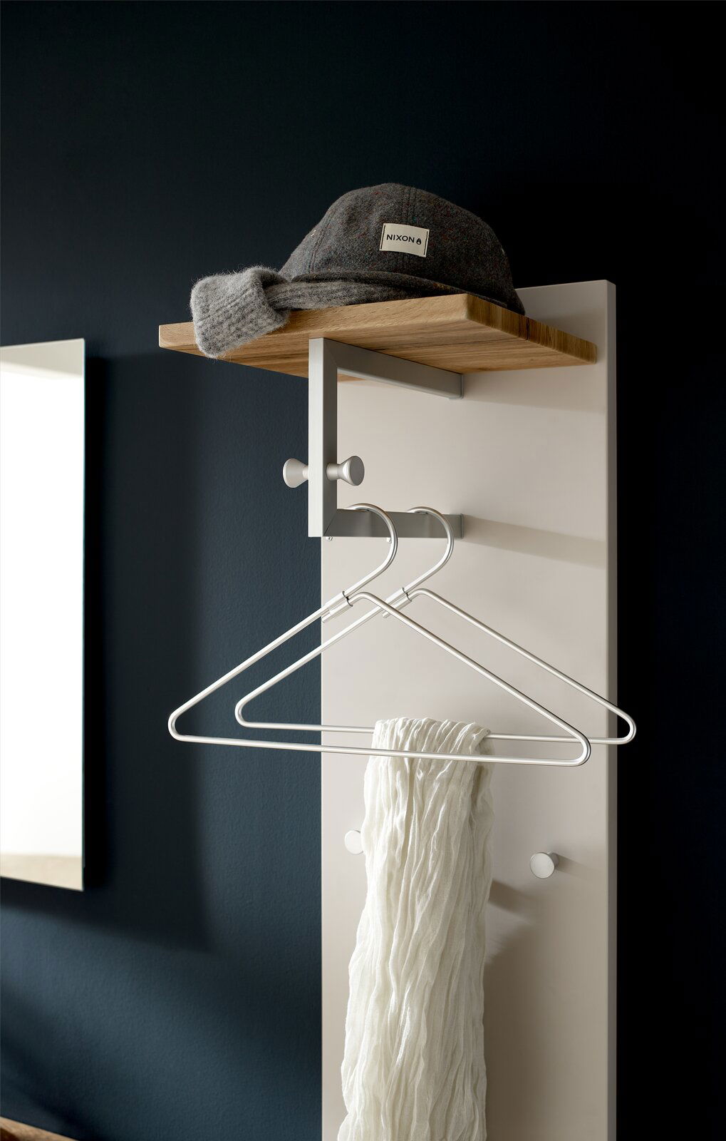 Garderobenpaneel mit Holzablage, Haken und Kleiderbügeln, seitliche Perspektive