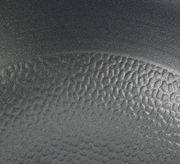 Nahaufnahme der strukturierten Oberfläche einer Wokpfanne COUNTRY, 28 cm, in schwarzer Farbe.