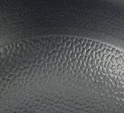 Nahaufnahme der strukturierten Oberfläche einer Wokpfanne COUNTRY, 28 cm, in schwarzer Farbe.