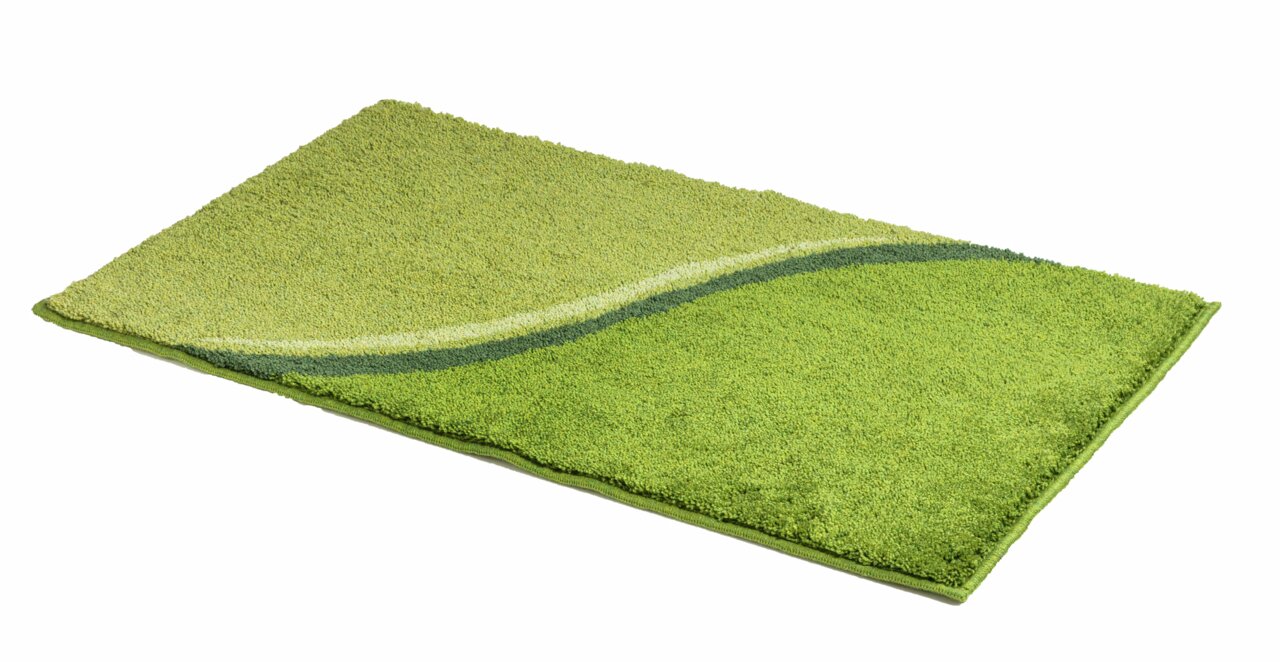 Grüner Badteppich mit wellenförmigem Muster, perspektivisch von der Seite fotografiert.