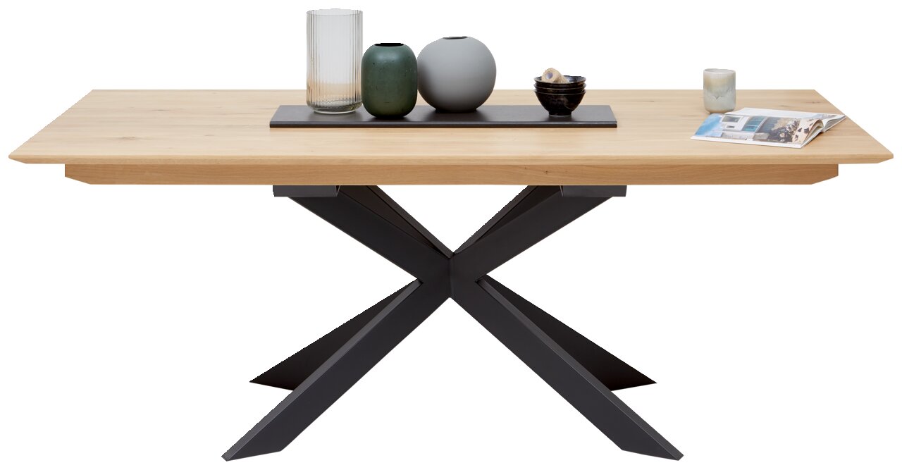 Moderner Esstisch mit Holzplatte und schwarzem X-förmigem Metallgestell, frontal fotografiert. Dekoriert mit Vasen und Kerzen.