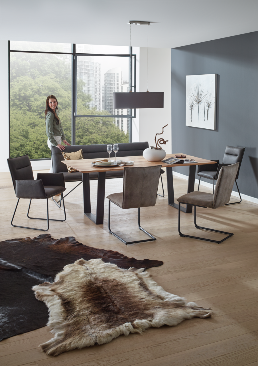 Valnatura Stuhl SCALA Moderne Esszimmer-Szene mit einem Holztisch und Freischwinger-Stühlen, seitliche Perspektive.