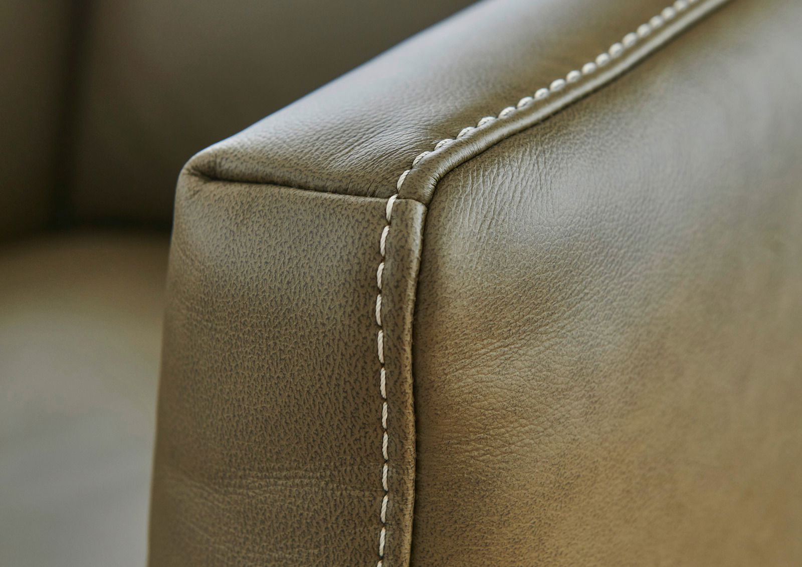 Nahaufnahme einer Sofaecke mit feiner Naht und Lederstruktur, seitliche Perspektive