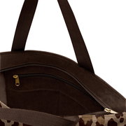 Innenansicht einer braunen Tasche mit Reißverschluss und Leo-Muster, Perspektive von oben.