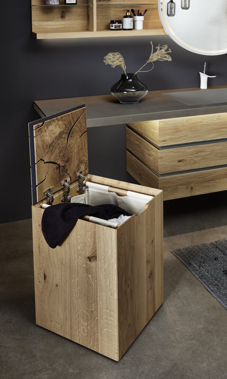 Wäschebox auf Rollen aus Holz mit geöffnetem Deckel, seitliche Perspektive, im modernen Badezimmer platziert.