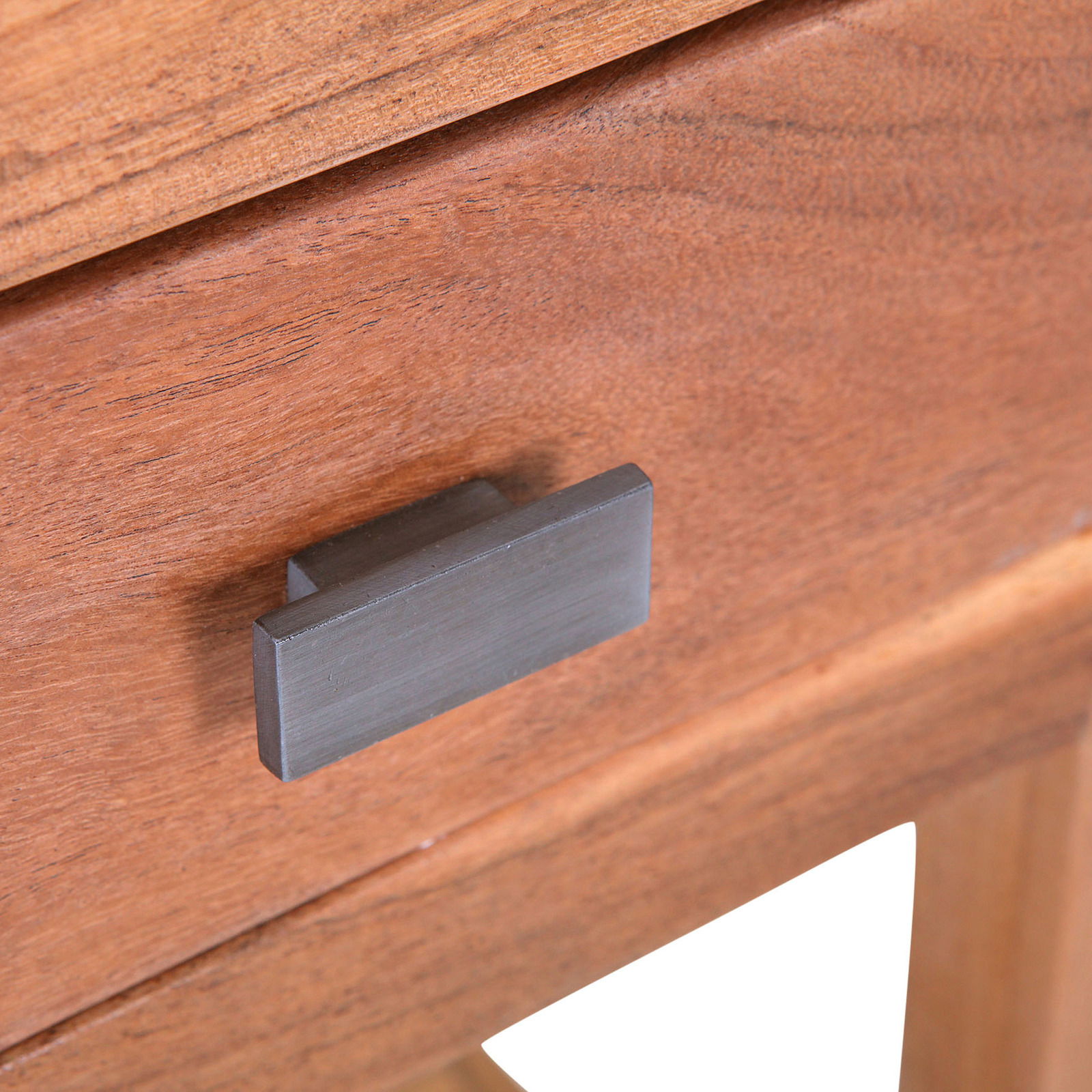 Nahaufnahme eines Holz-Beistelltisches mit einer Schublade und einem dunklen Griff, Perspektive von vorne.