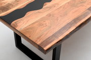 Nahaufnahme eines Esstisches mit einer Tischplatte aus Holz und schwarzem Harz, rechteckige Form, auf schwarzen Metallbeinen.