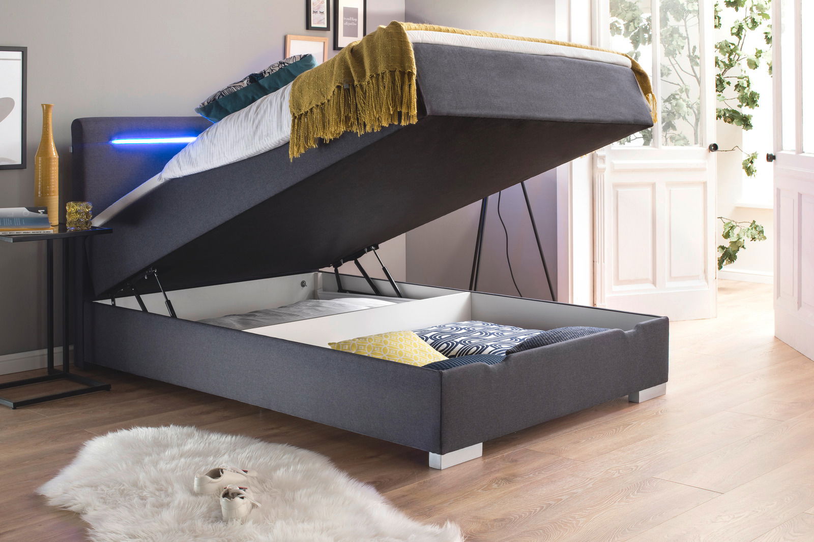 Boxbett mit hochgeklappter Matratze und Stauraum, seitliche Perspektive