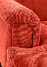 Nahaufnahme einer roten, strukturierten Polsterung einer 2er-Sitzbank, Fokus auf die Armlehne.