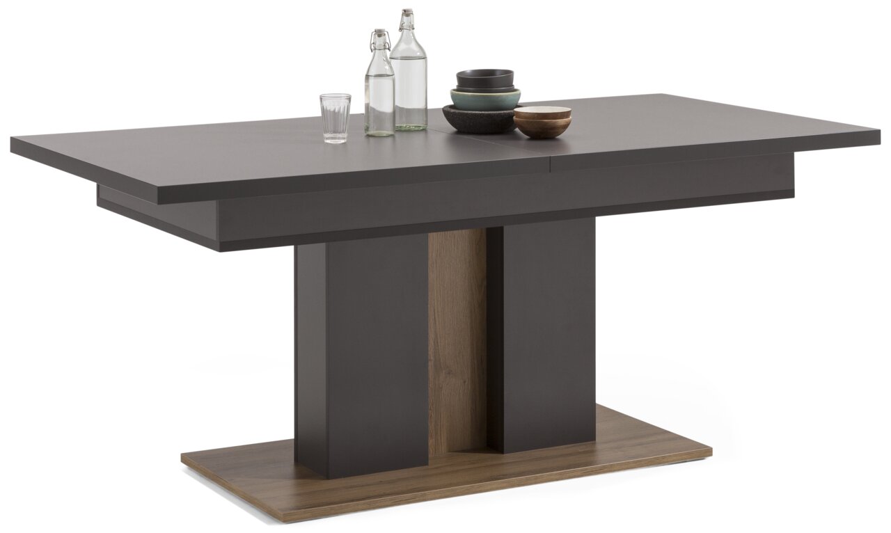 Set one by Musterring Esstisch TACOMA Moderner, ausziehbarer Esstisch in dunklem Holz mit zentralem Sockel, seitliche Perspektive.