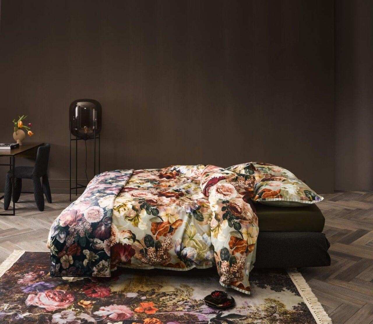 Bettwäsche-Set mit floralem Muster in einem stilvoll eingerichteten Schlafzimmer, seitliche Perspektive