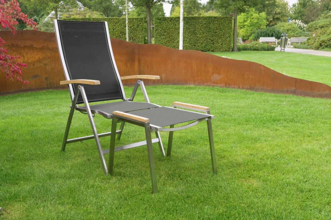 Moderner Hocker mit Metallrahmen und Holzarmlehnen, aufgestellt auf einer grünen Wiese, seitliche Perspektive