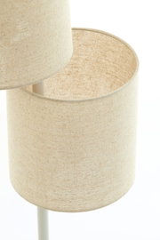 Close-up van twee op elkaar geplaatste, cilindervormige lampenkappen van beige stof, onderdeel van een staande lamp.