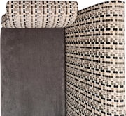 Nahaufnahme einer gepolsterten Möbel-Ecke mit grauer Stofffläche und gemustertem Bezug in Beige/Schwarz/Grau, Ansicht von schräg oben