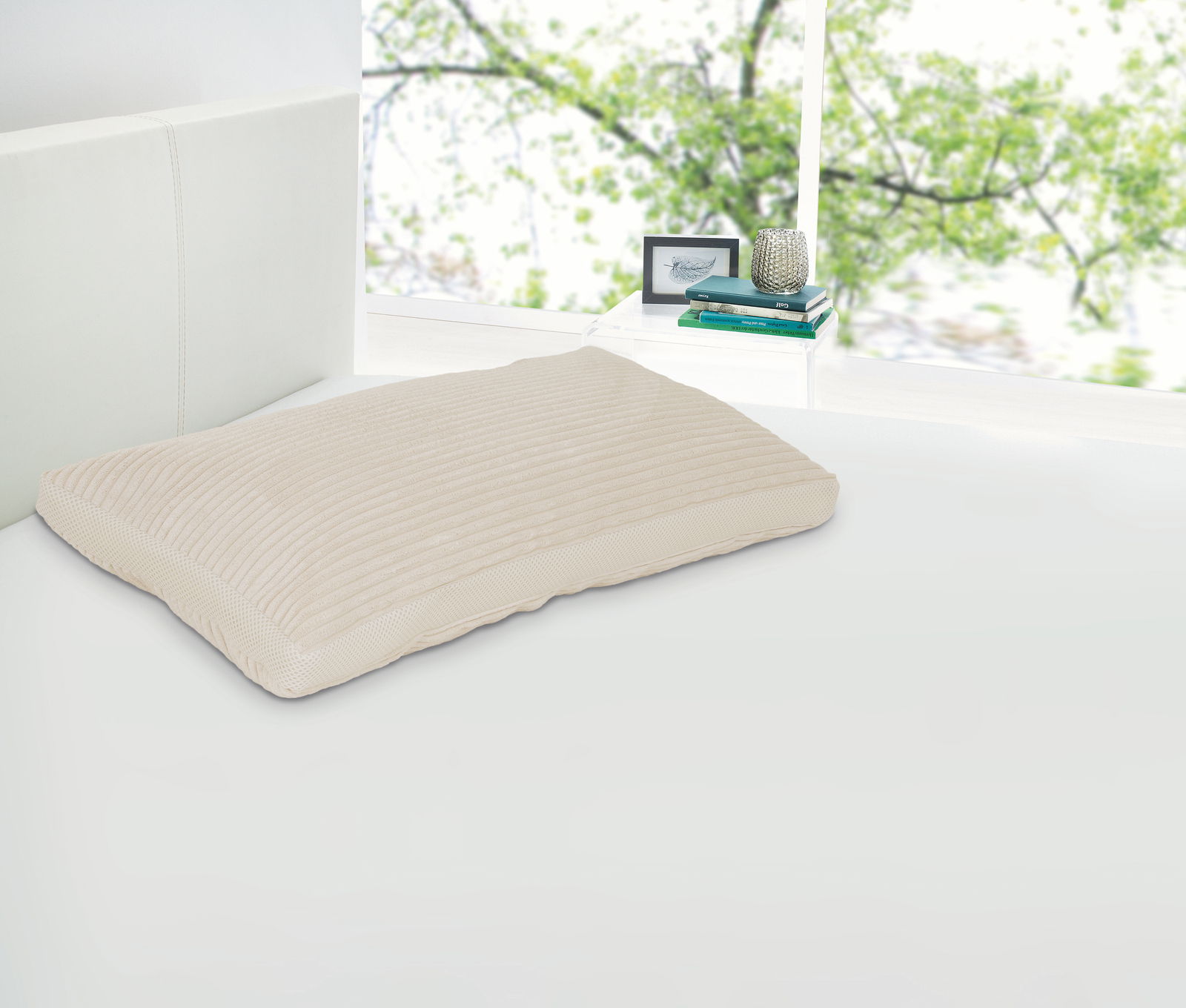 Intro Komfortschlafkissen CUPID Komfortschlafkissen 40 x 80 cm auf einem Bett, seitliche Perspektive, mit einem Fenster im Hintergrund