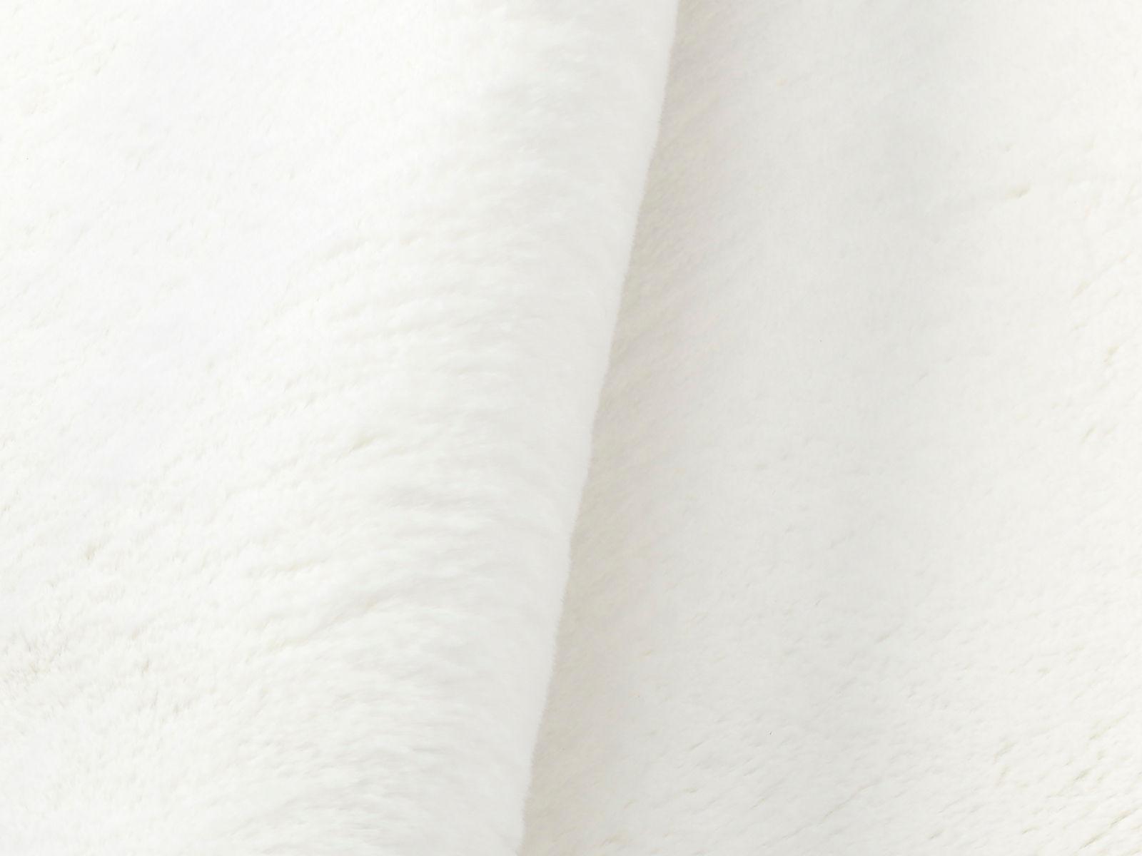 Nahaufnahme eines weißen Fellteppichs in seitlicher Perspektive